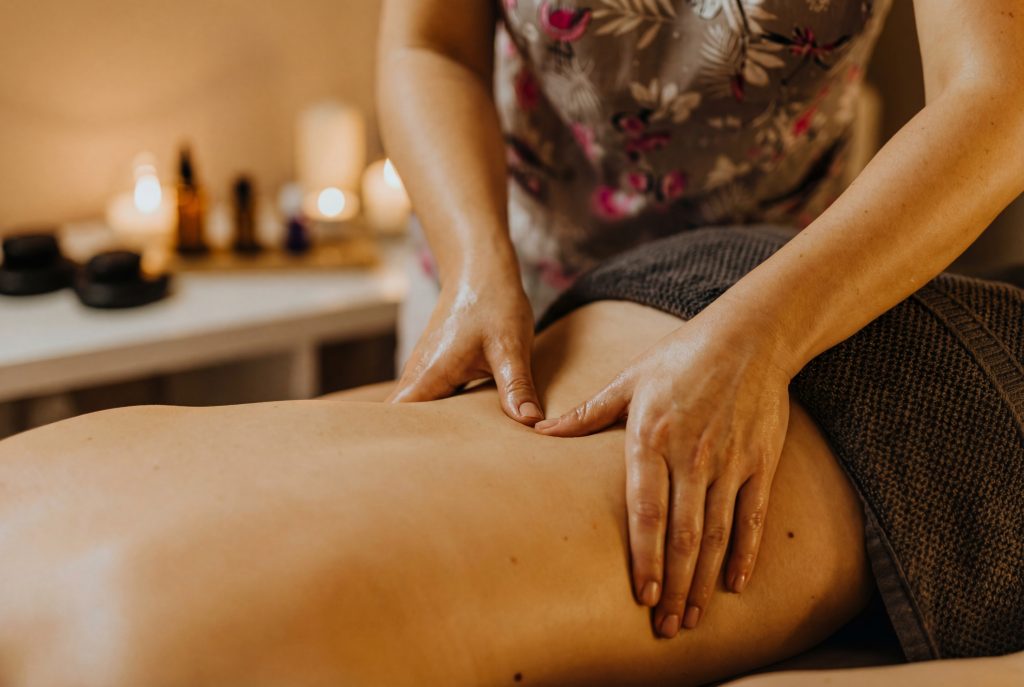 Praticienne effectuant un massage lombaire thérapeutique avec huile pour détendre les muscles et soulager les douleurs du bas du dos liées aux règles douloureuses en médecine traditionnelle chinoise  